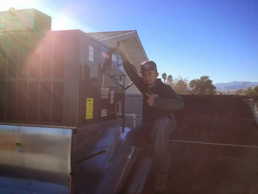 HVAC technician performing AC Tune-Up on a rooftop unit in Yazoo City